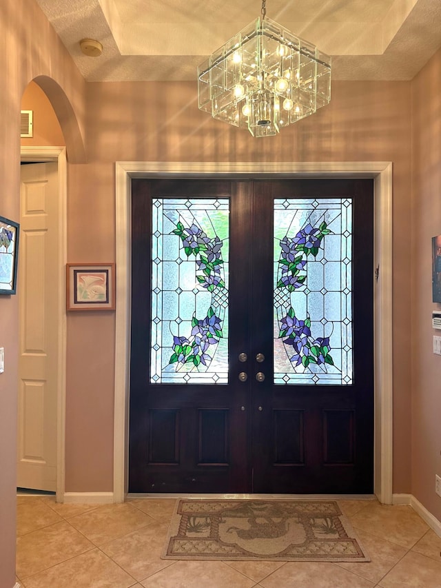 473 Cottagewood Ln, West Palm Beach, FL 33411 - tiled foyer featuring a chandelier, arched walkways, baseboards, and french doors