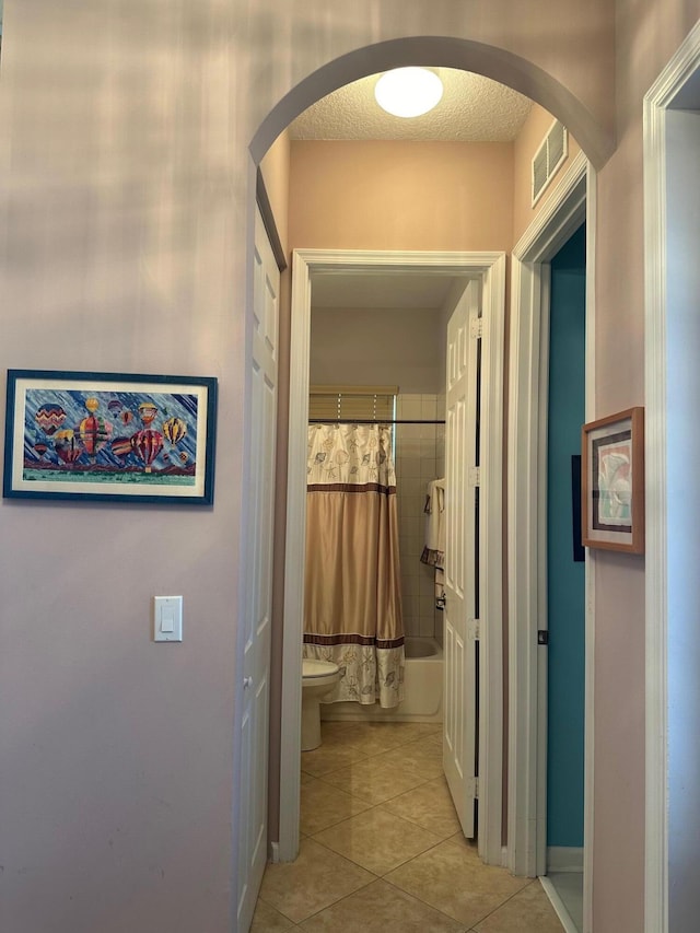 473 Cottagewood Ln, West Palm Beach, FL 33411 - hall with arched walkways, light tile patterned floors, and baseboards