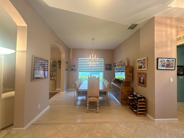 473 Cottagewood Ln, West Palm Beach, FL 33411 - tiled dining area with a chandelier, arched walkways, and baseboards