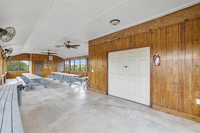 32801 US Highway 441 N Unit 64, Okeechobee, FL 34972 - unfurnished living room featuring wood walls, vaulted ceiling, concrete floors, ceiling fan, and baseboards