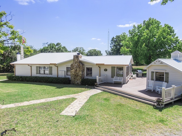 32801 US Highway 441 N Unit 64, Okeechobee, FL 34972 - view of front of home featuring a chimney, a wooden deck, metal roof, and a front yard