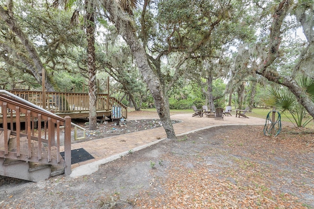 32801 US Highway 441 N Unit 64, Okeechobee, FL 34972 - view of yard with an outdoor fire pit, a deck, and view of wooded area