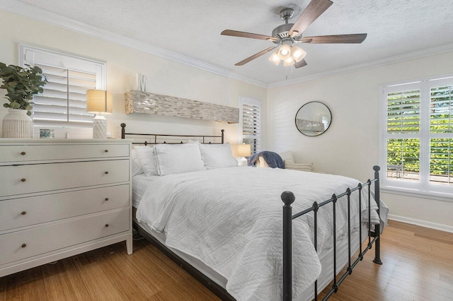 903 Oak Cir, Jupiter, FL 33458 - bedroom with wood finished floors, ornamental molding, a textured ceiling, baseboards, and ceiling fan