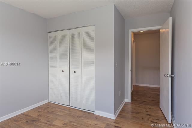 2167 Champions Way N, Lauderdale, FL 33068 - unfurnished bedroom with a closet, wood finished floors, and baseboards