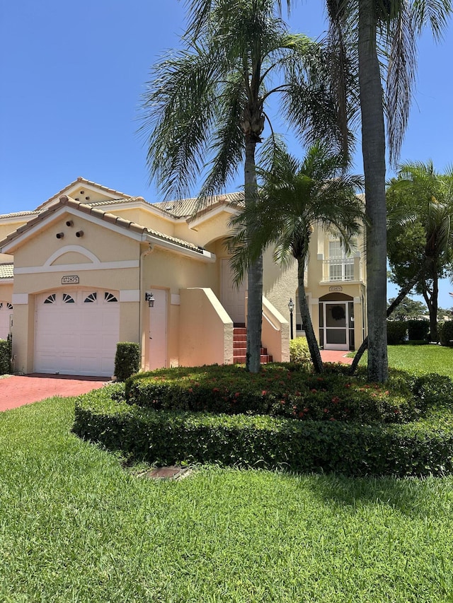 17287 Boca Club 1 Blvd Unit 1, Boca Raton, FL 33487 - mediterranean / spanish house featuring stucco siding, a garage, driveway, and a front lawn