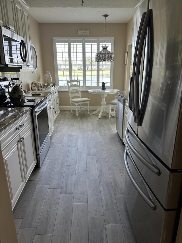 17287 Boca Club 1 Blvd Unit 1, Boca Raton, FL 33487 - kitchen featuring stainless steel appliances, wood finished floors, baseboards, hanging light fixtures, and white cabinetry