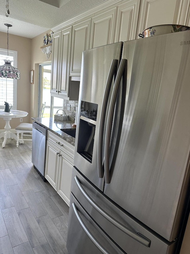 17287 Boca Club 1 Blvd Unit 1, Boca Raton, FL 33487 - kitchen featuring stainless steel appliances, stone countertops, wood finished floors, a textured ceiling, and tasteful backsplash