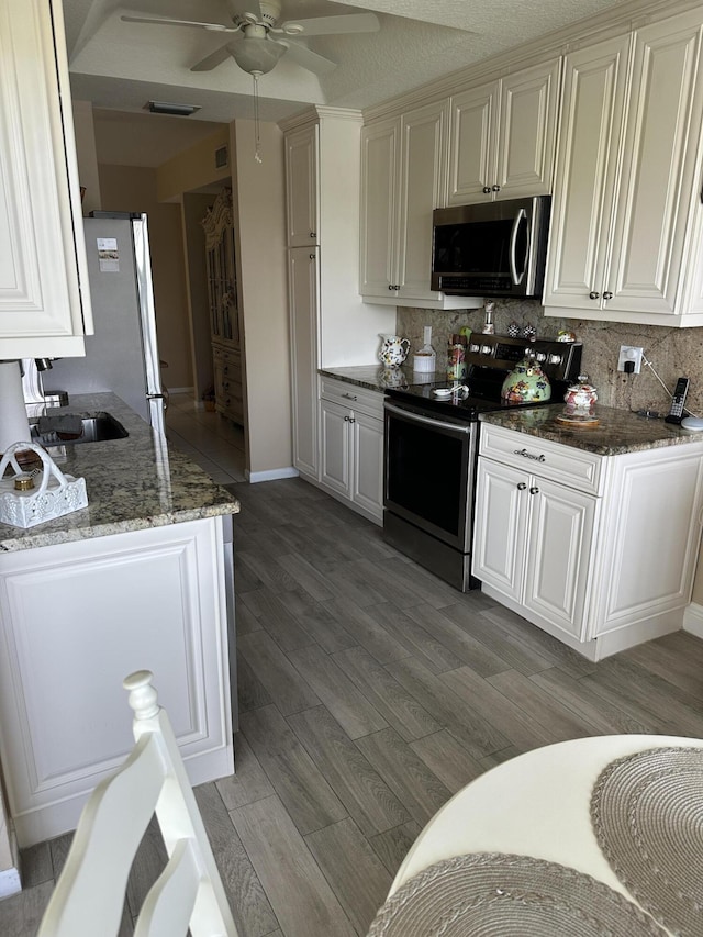 17287 Boca Club 1 Blvd Unit 1, Boca Raton, FL 33487 - kitchen featuring stainless steel appliances, light wood-type flooring, ceiling fan, decorative backsplash, and stone countertops