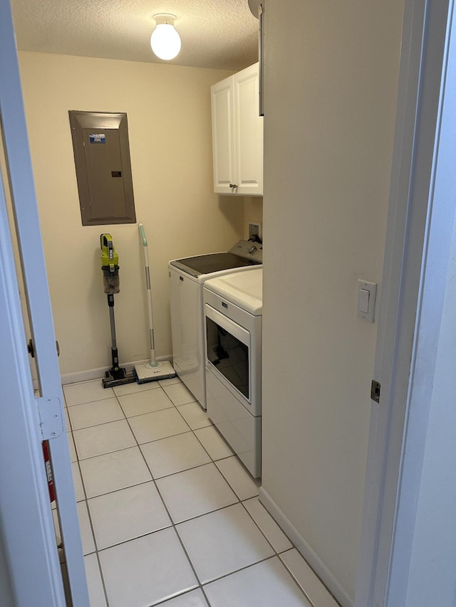 17287 Boca Club 1 Blvd Unit 1, Boca Raton, FL 33487 - washroom featuring electric panel, cabinet space, washing machine and clothes dryer, a textured ceiling, and light tile patterned floors