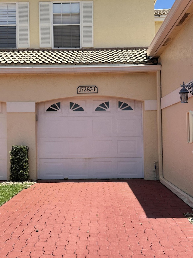 17287 Boca Club 1 Blvd Unit 1, Boca Raton, FL 33487 - garage featuring decorative driveway