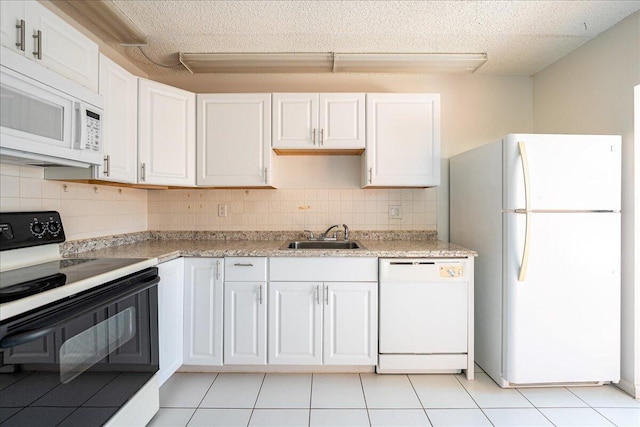 kitchen featuring white appliances, a sink, white cabinetry, backsplash, and light countertops
