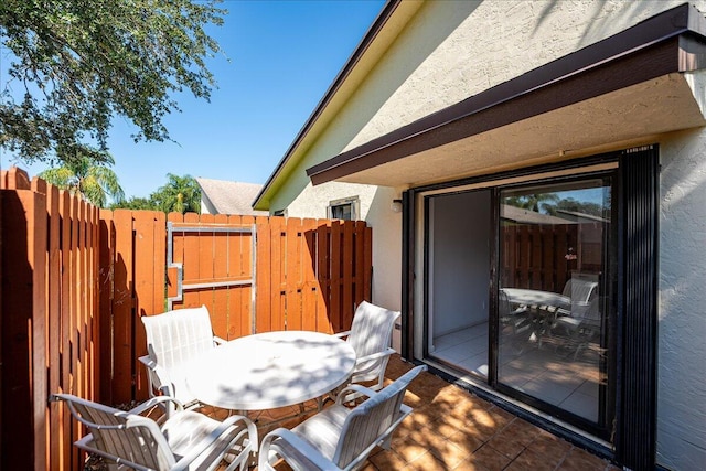view of patio featuring a gate, fence, and outdoor dining area