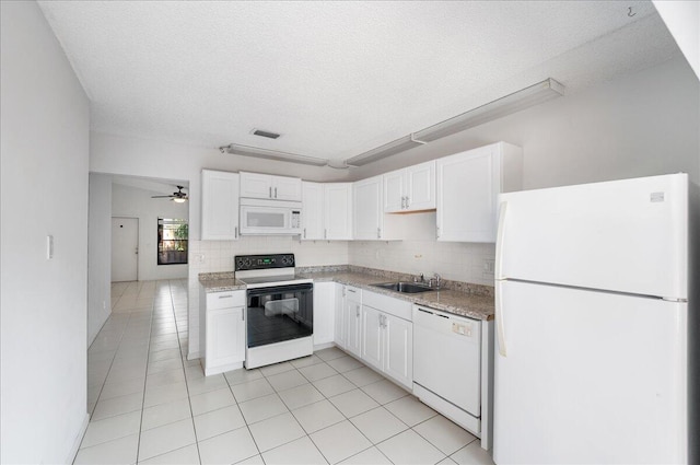 kitchen featuring white appliances, light tile patterned flooring, white cabinets, a textured ceiling, and tasteful backsplash