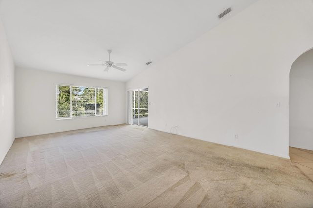 unfurnished room featuring arched walkways, ceiling fan, lofted ceiling, and light carpet