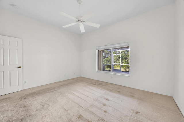 carpeted empty room featuring a ceiling fan