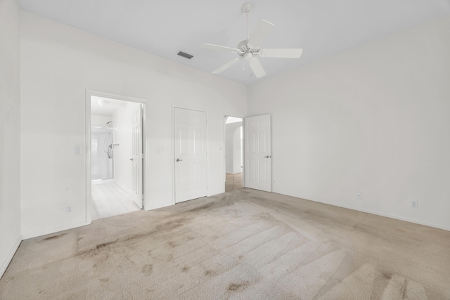 unfurnished bedroom with carpet, connected bathroom, and ceiling fan