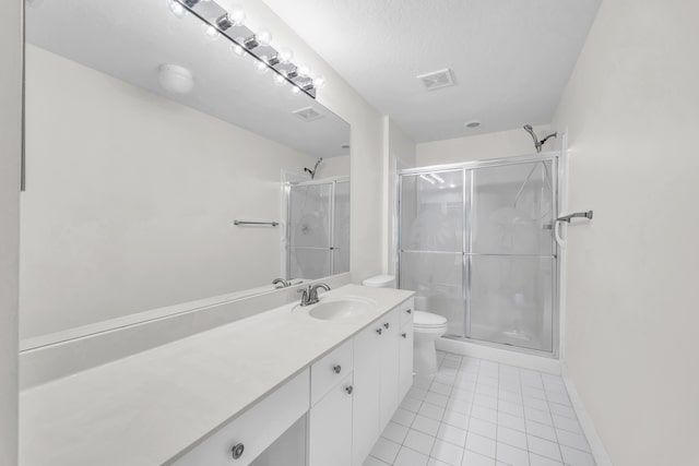 bathroom featuring tile patterned flooring, a shower stall, vanity, toilet, and baseboards