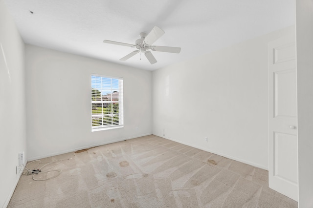 spare room featuring carpet floors, ceiling fan, and baseboards