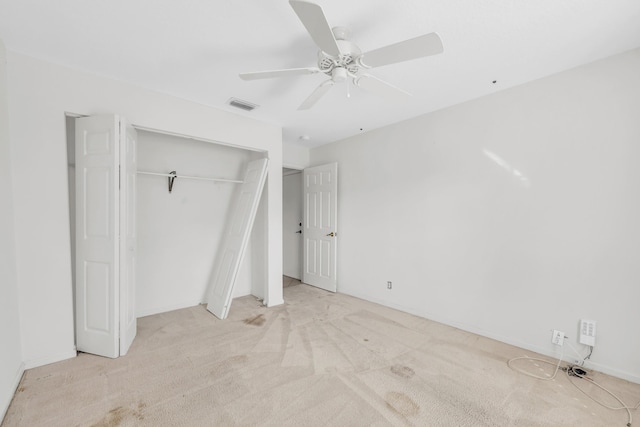 unfurnished bedroom with a closet, carpet floors, a ceiling fan, and baseboards