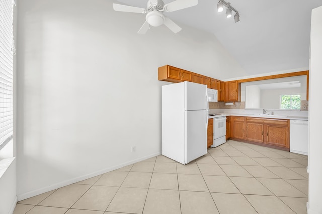 kitchen featuring white appliances, light countertops, vaulted ceiling, light tile patterned flooring, and ceiling fan
