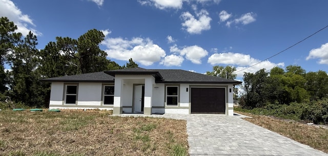 382 Mcarthur Blvd, Lehigh Acres, FL 33974 - prairie-style house featuring stucco siding, a garage, decorative driveway, and a shingled roof