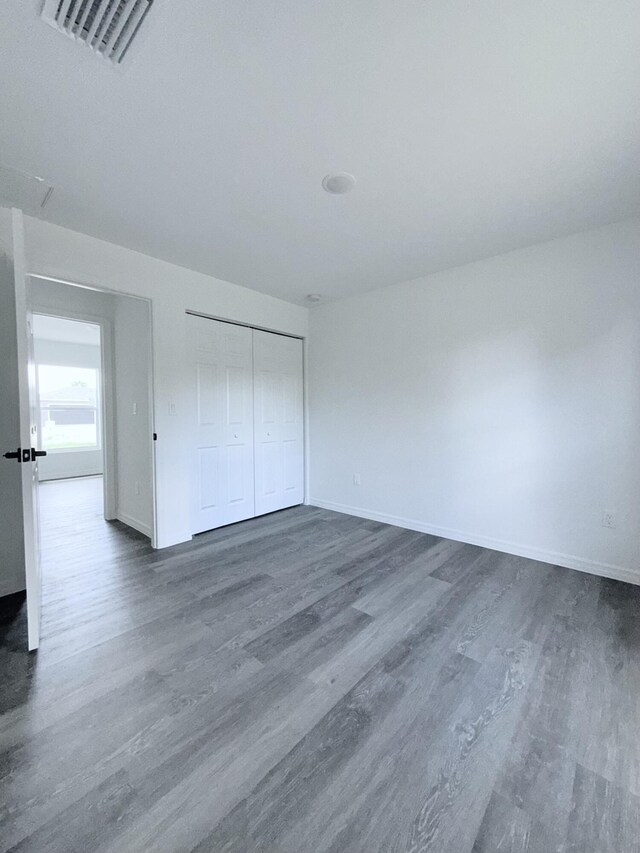 382 Mcarthur Blvd, Lehigh Acres, FL 33974 - unfurnished bedroom featuring dark wood-type flooring, baseboards, and a closet