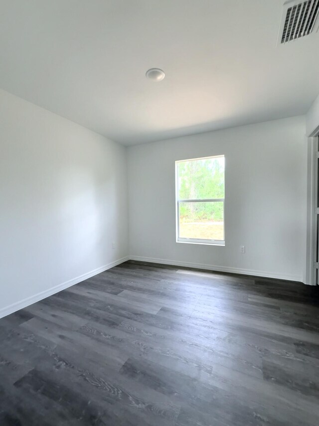 382 Mcarthur Blvd, Lehigh Acres, FL 33974 - spare room featuring baseboards and dark wood-type flooring