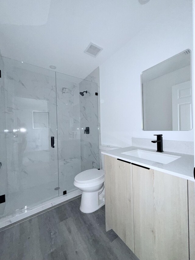 382 Mcarthur Blvd, Lehigh Acres, FL 33974 - bathroom with toilet, a marble finish shower, wood finished floors, and vanity