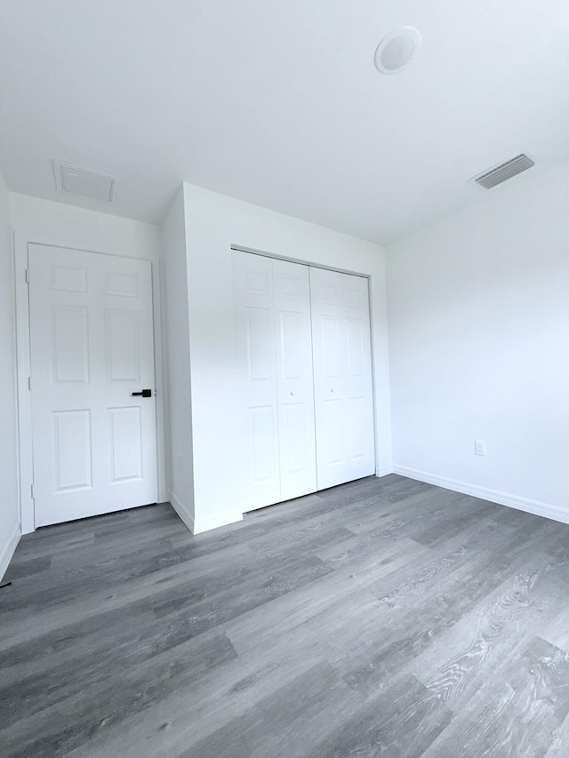 382 Mcarthur Blvd, Lehigh Acres, FL 33974 - unfurnished bedroom with wood finished floors, baseboards, and a closet