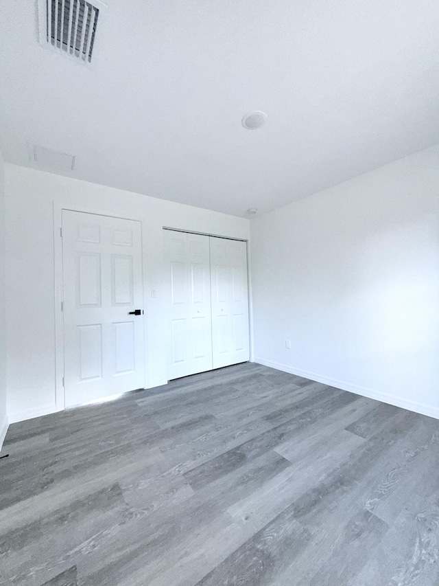 382 Mcarthur Blvd, Lehigh Acres, FL 33974 - unfurnished bedroom with wood finished floors, a closet, and baseboards