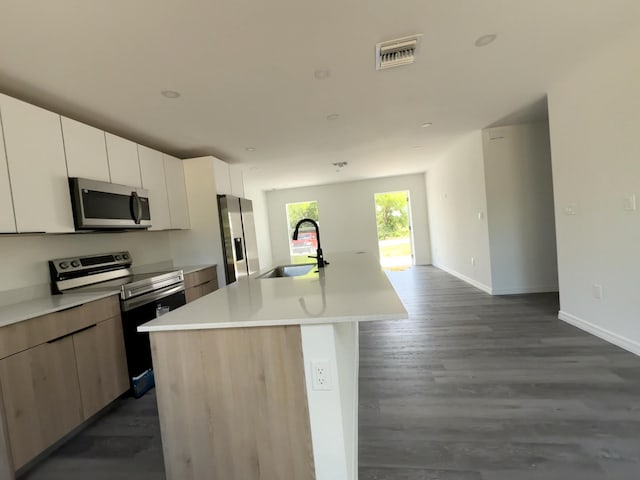 382 Mcarthur Blvd, Lehigh Acres, FL 33974 - kitchen featuring appliances with stainless steel finishes, a sink, a center island with sink, light countertops, and baseboards