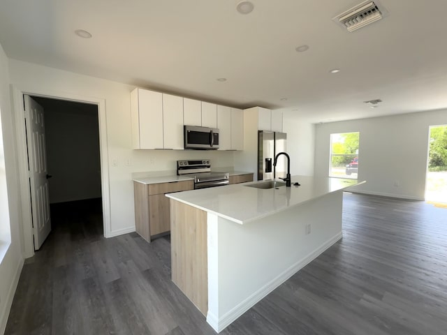 382 Mcarthur Blvd, Lehigh Acres, FL 33974 - kitchen featuring stainless steel appliances, a sink, dark wood-style floors, an island with sink, and light countertops