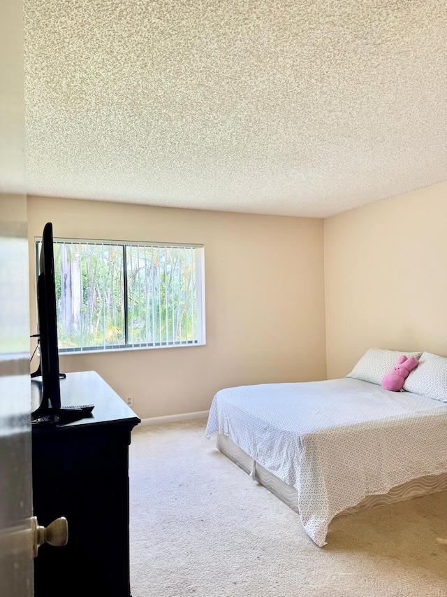 bedroom with carpet and a textured ceiling