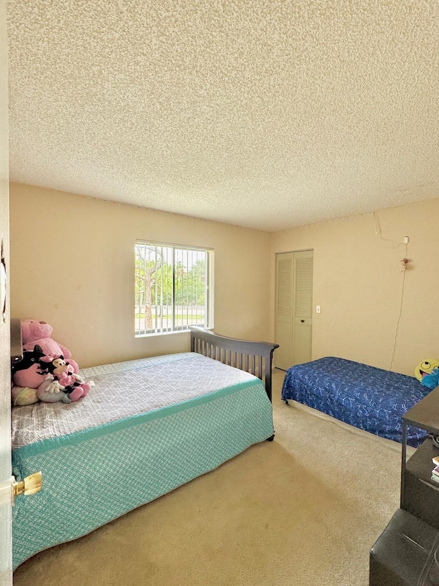 bedroom with a textured ceiling and carpet flooring