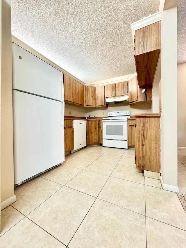 kitchen with white appliances, under cabinet range hood, a textured ceiling, brown cabinets, and light tile patterned flooring