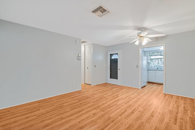 unfurnished room featuring ceiling fan, light wood-type flooring, and baseboards