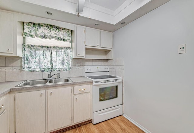 kitchen with white range with electric stovetop, a sink, light countertops, and light wood-type flooring