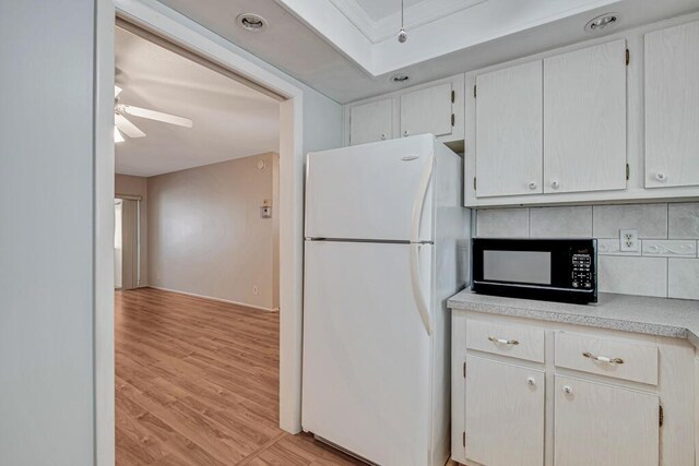 kitchen featuring freestanding refrigerator, black microwave, light countertops, light wood-style floors, and ceiling fan