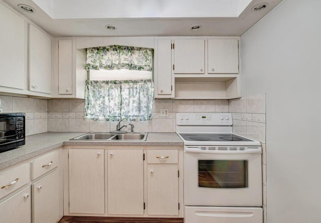 kitchen with white electric range oven, a sink, light countertops, black microwave, and backsplash