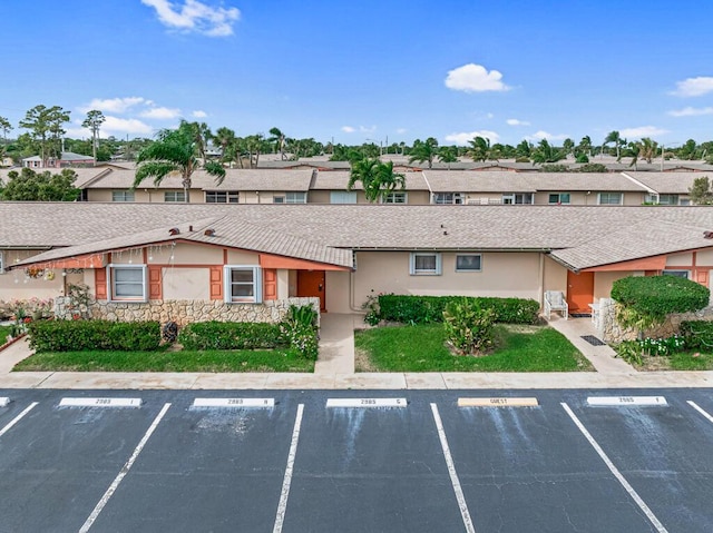 view of property with uncovered parking and a residential view