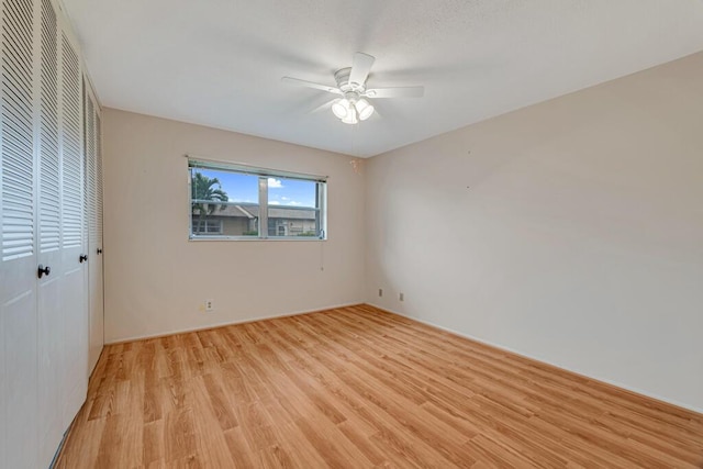 unfurnished bedroom with light wood-style floors, a closet, and ceiling fan