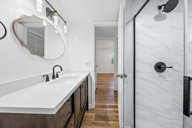 12416 Alternate A1A P7, Palm Beach Gardens, FL 33410 - bathroom with tiled shower, vanity, and wood finished floors