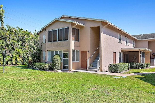 12416 Alternate A1A P7, Palm Beach Gardens, FL 33410 - back of house featuring stucco siding and a lawn