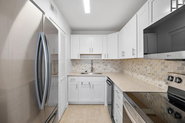 12416 Alternate A1A P7, Palm Beach Gardens, FL 33410 - kitchen with appliances with stainless steel finishes, a sink, white cabinets, backsplash, and light tile patterned floors