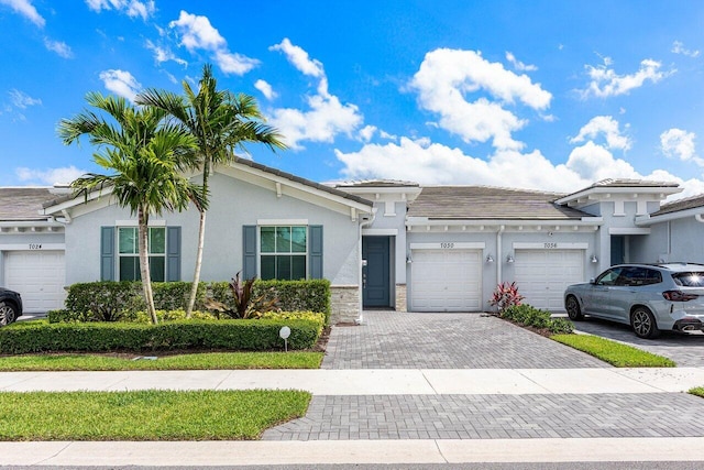 7030 Peters Ln, Delray Beach, FL 33446 - view of front facade featuring a garage, driveway, stucco siding, and stone siding