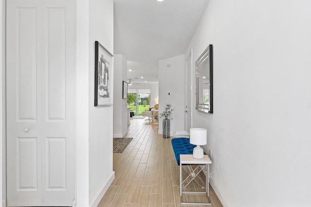 7030 Peters Ln, Delray Beach, FL 33446 - hall with baseboards, wood finished floors, and a textured ceiling