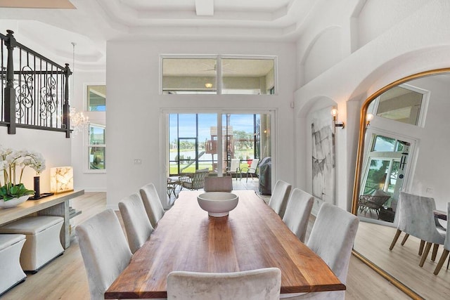 138 NW Magnolia Lakes Blvd, Port Saint Lucie, FL 34986 - dining space with a high ceiling, light wood-style floors, arched walkways, a water view, and coffered ceiling