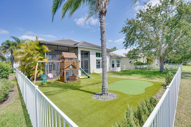 138 NW Magnolia Lakes Blvd, Port Saint Lucie, FL 34986 - view of yard featuring a putting area, a playground, and a sunroom