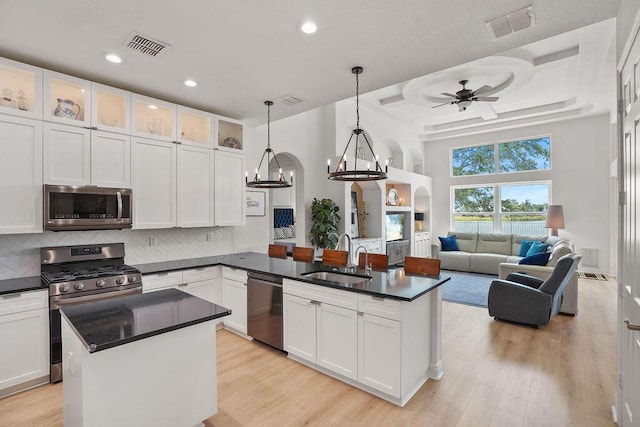 138 NW Magnolia Lakes Blvd, Port Saint Lucie, FL 34986 - kitchen featuring appliances with stainless steel finishes, a sink, a peninsula, dark countertops, and a ceiling fan
