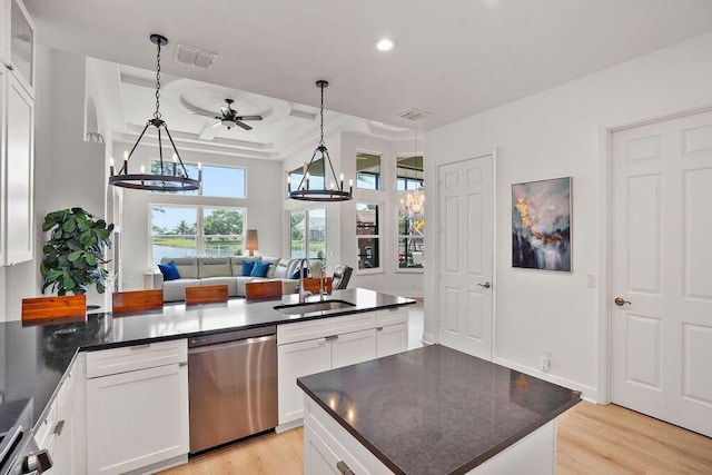 138 NW Magnolia Lakes Blvd, Port Saint Lucie, FL 34986 - kitchen with stainless steel dishwasher, a sink, dark countertops, light wood-type flooring, and ceiling fan
